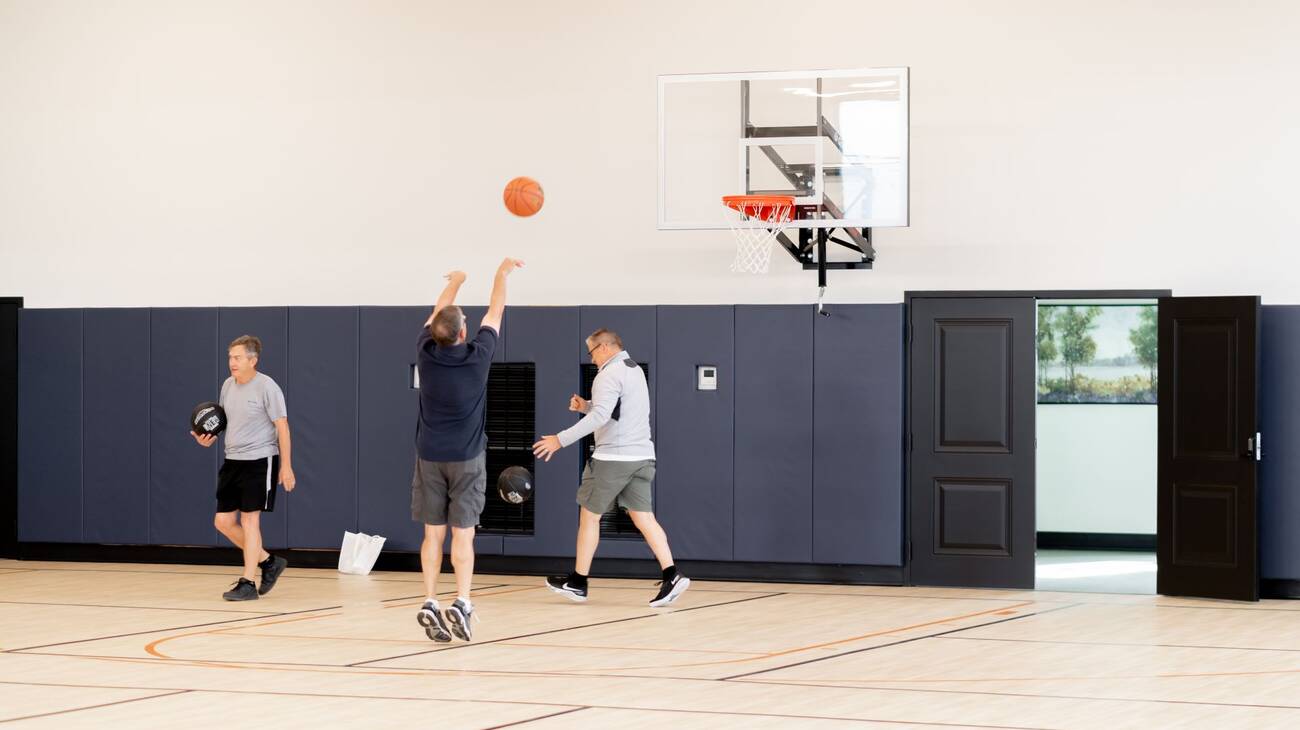 A group of active adults playing a game of basketball.