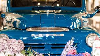 A blue vintage truck surrounded by decorations parked inside Amblebrook welcome center.