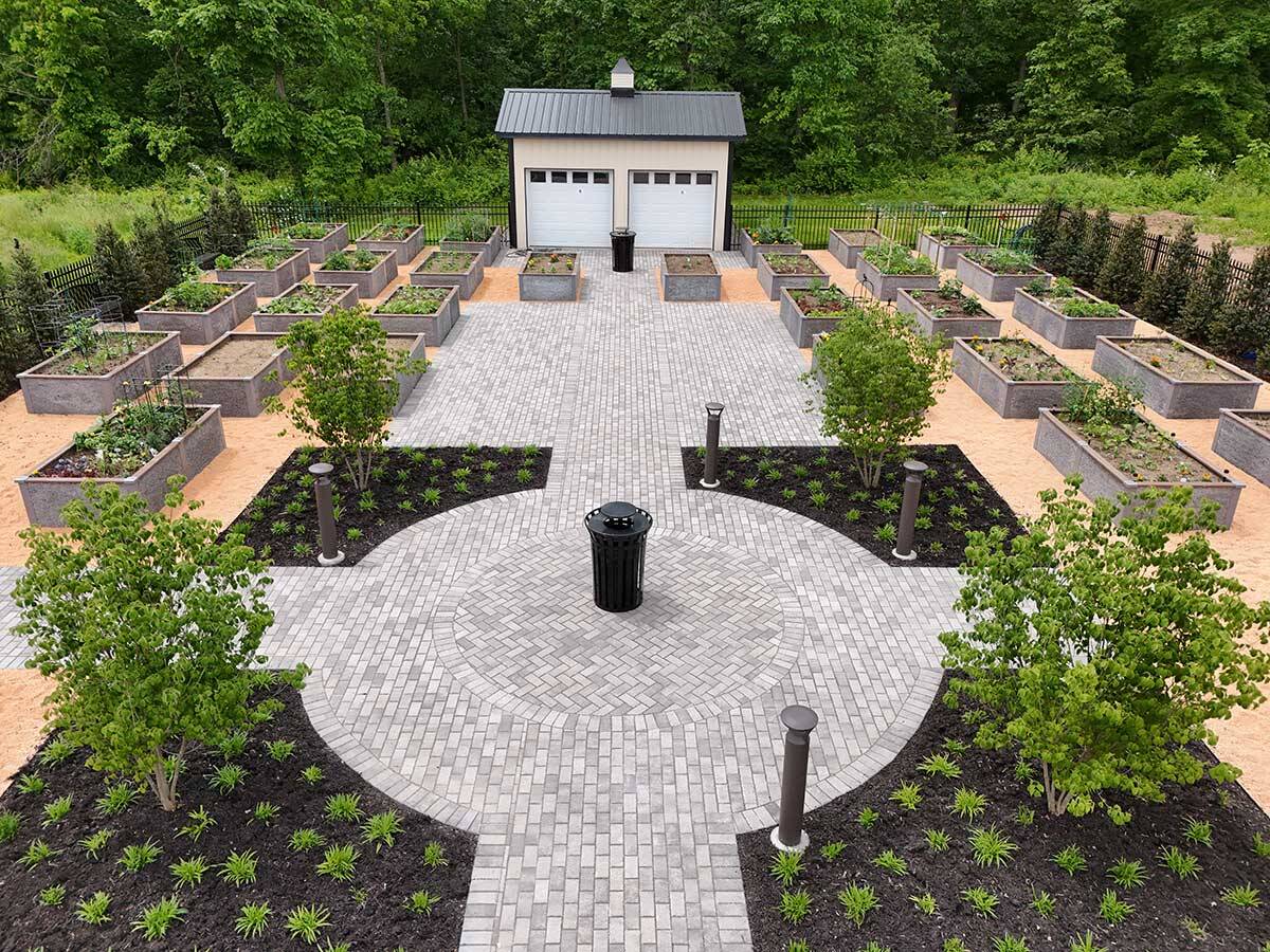 Aerial view of new Amblebrook community garden with sprouting plants, concrete walkways, and benches