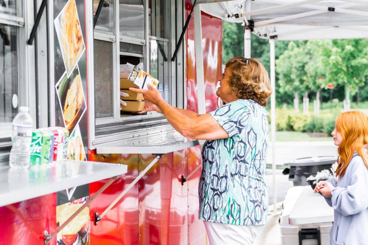 Amblebrook resident purchasing food from a food truck with their grandkid. 