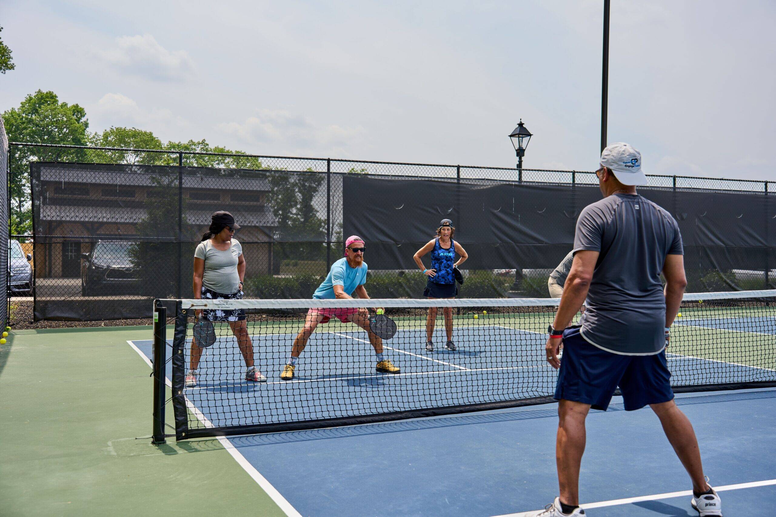 Active adults playing pickleball on dedicated outdoor court during midday