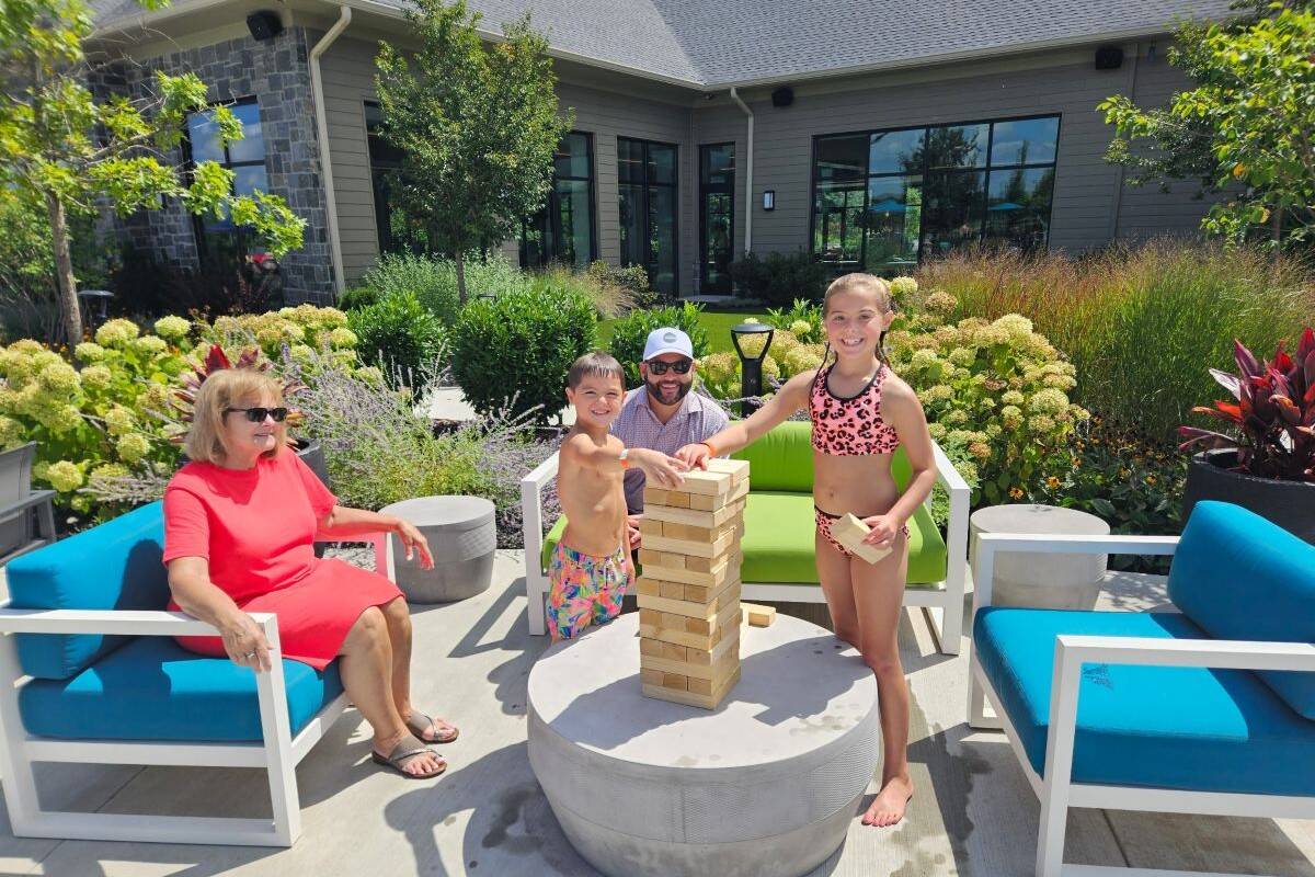 Grandparents spending an afternoon with their grandchildren by the pool.
