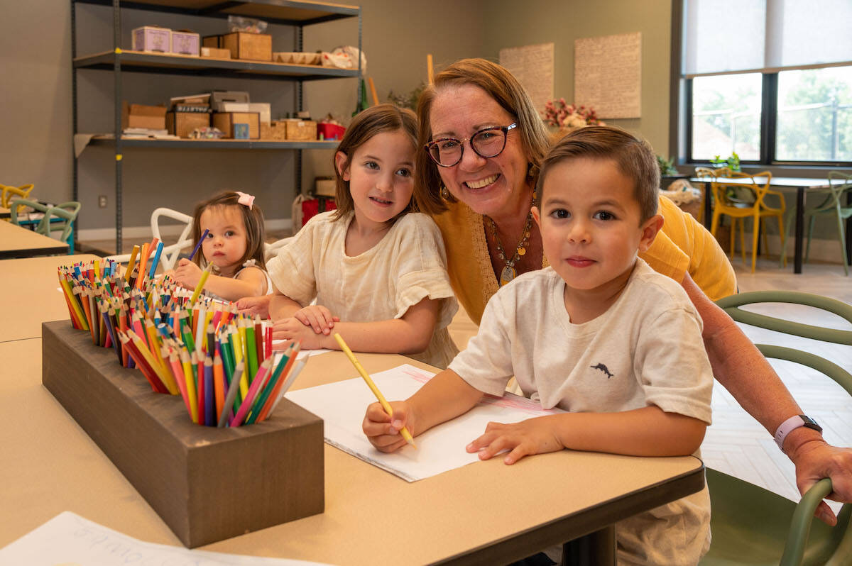 Grandma wearing a yellow shirt in the middle of her two grandchildren at Amblebrook