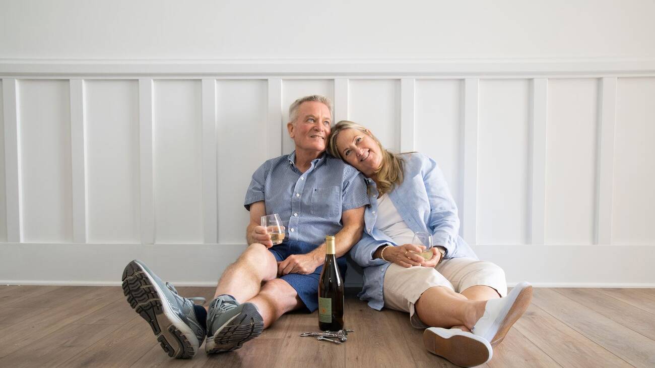 Retired couple sharing wine in the new home they have purchased together