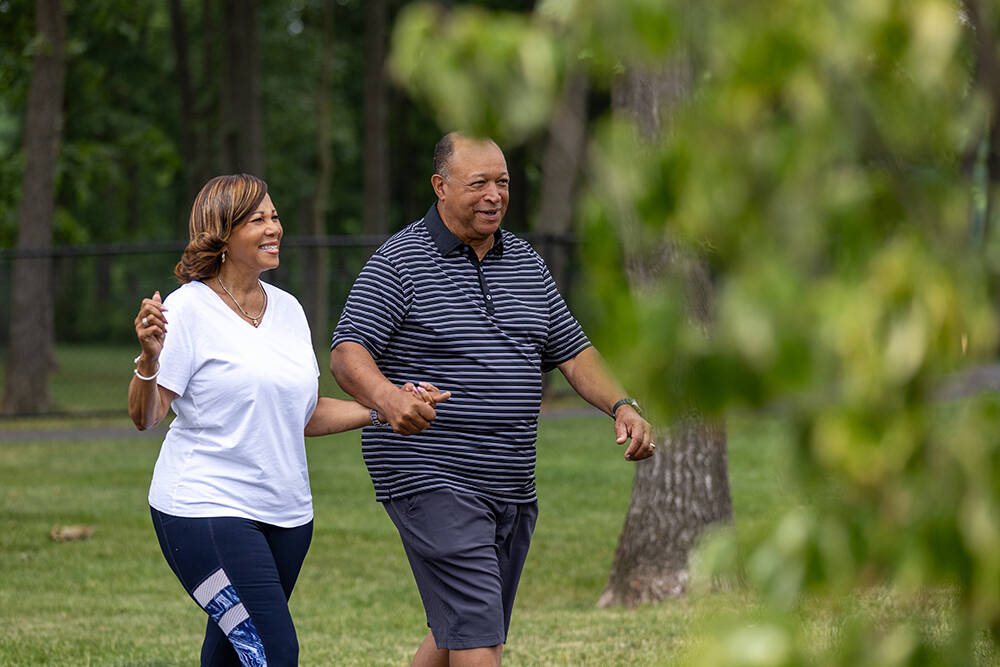 Couple holding hands and laughing in the park during 5k race